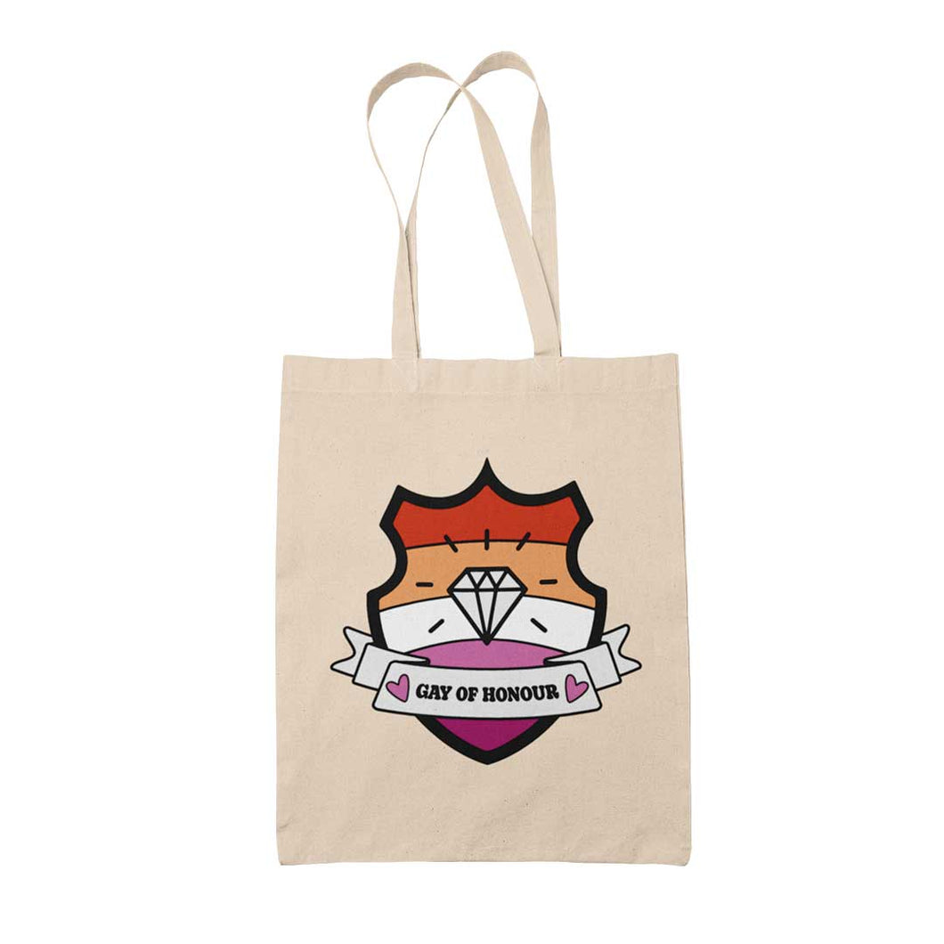Natural coloured tote bag featuring a shield with a banner across it's front. Banner reads Gay of Honour. The background of the shield is the lesbian pride flag and there is a jewel icon in the centre.