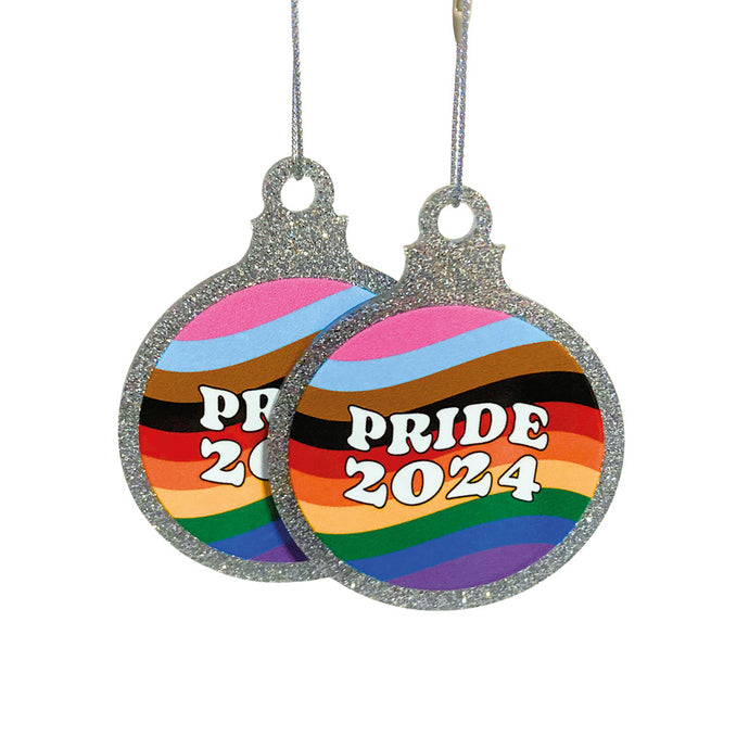 Two flat silver glitter baubles on a white background. Each bauble has a Pride 2024 design on the front with wavy lines in the colour of the progress pride flag.
