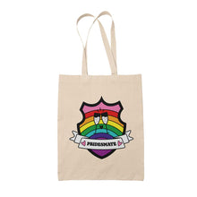 Load image into Gallery viewer, Natural coloured tote bag featuring a shield with a banner across it&#39;s front. Banner reads Pridesmate. The background of the shield is the Gilbert Baker pride flag and there is a pair of clinking champagne flutes in the centre.