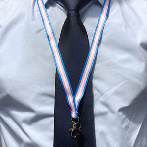 Person wearing a lanyard in the colours of the transgender flag over a shirt and tie.