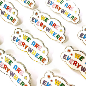A collection of We Are Everywhere enamel pins lined up in rows
