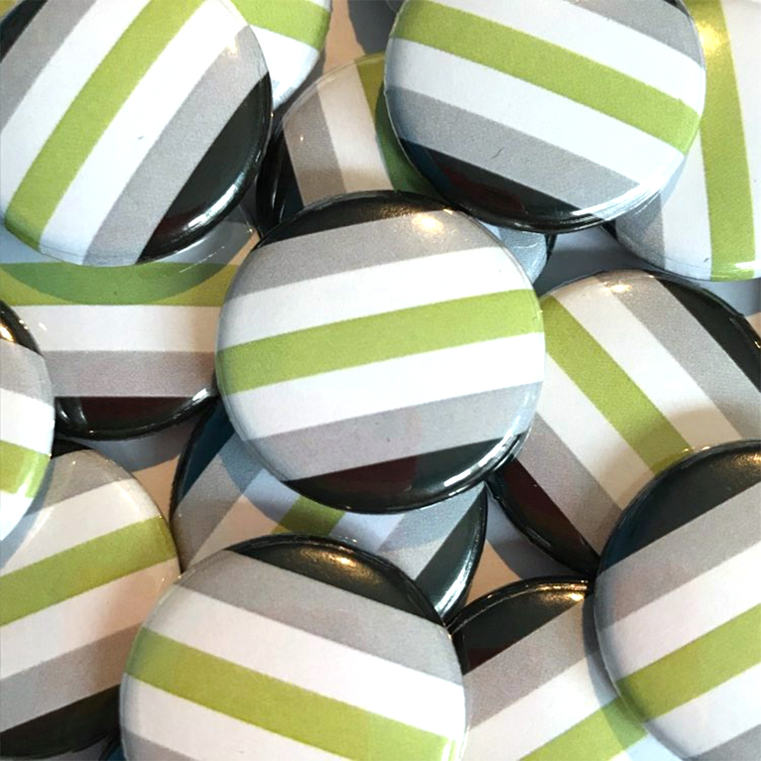 A pile of Agender flag badges