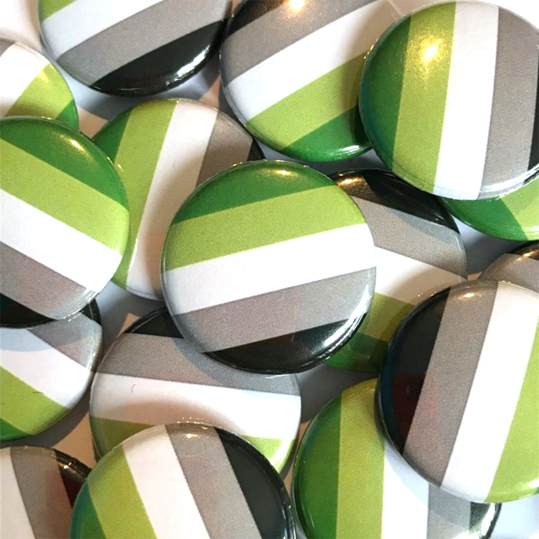 A pile of aromantic flag badges