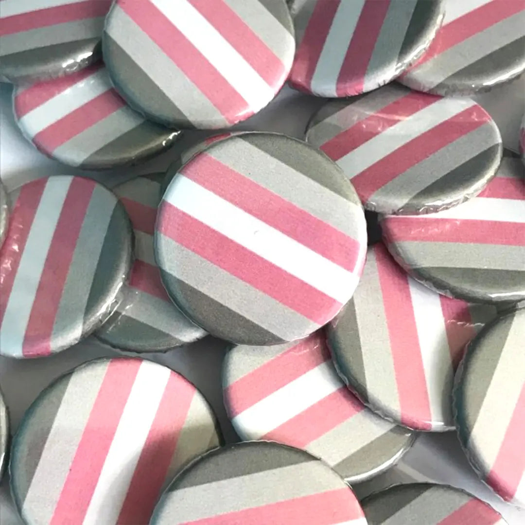A pile of demigirl flag badges