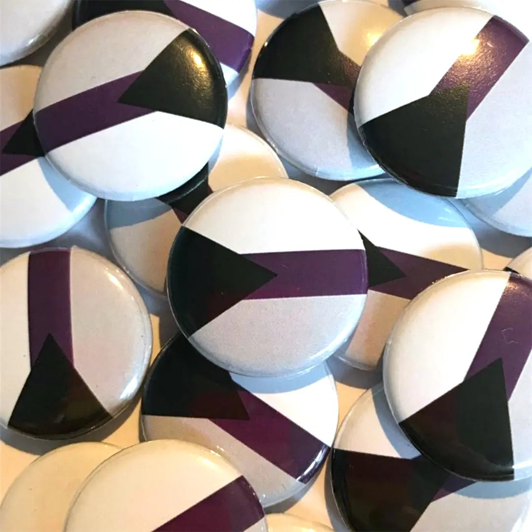 A pile of demisexual flag badges