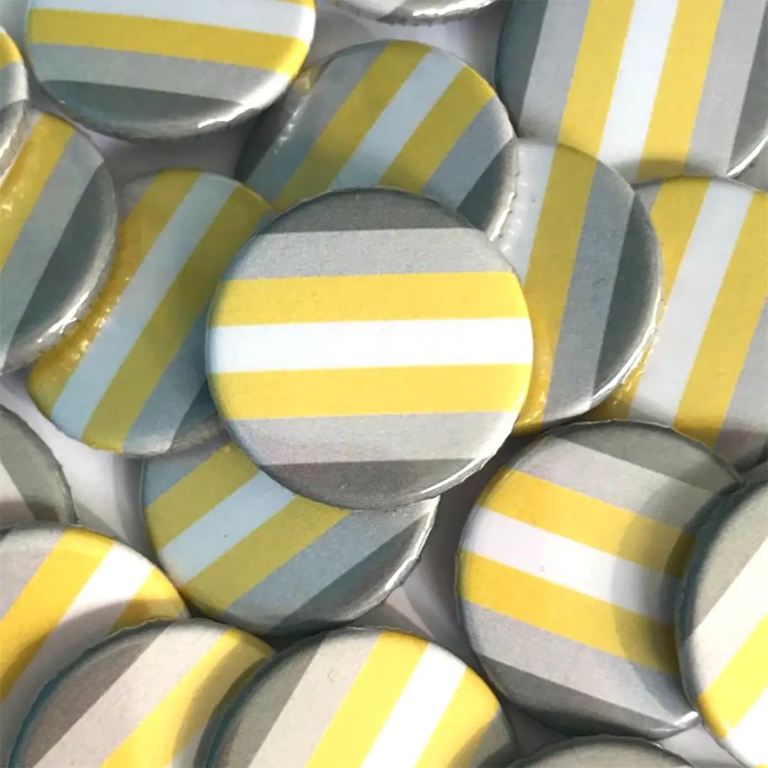 A pile of demigender flag badges