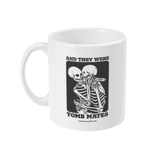 Load image into Gallery viewer, A white ceramic coffee mug with the handle on the left. The mug shows two skeletons embracing and the text &#39;And They Were Tomb Mates&#39;