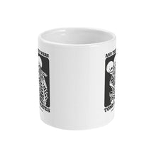 Load image into Gallery viewer, A white ceramic coffee mug with handle facing away from view. The mug shows two skeletons embracing and the text &#39;And They Were Tomb Mates&#39;