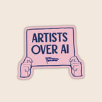 Artists Over AI vinyl sticker featuring illustrated hands holding a pink protest sign with the words "Artists Over AI".