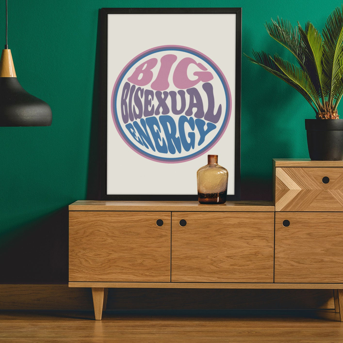 A framed Big Bisexual Energy poster on a dark green wall, adding a bold, retro aesthetic to the space.