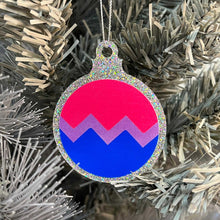 Load image into Gallery viewer, Close up of a white Christmas tree displaying a silver glitter bauble featuring a classic zig zag design in the colours of the bisexual pride flag.