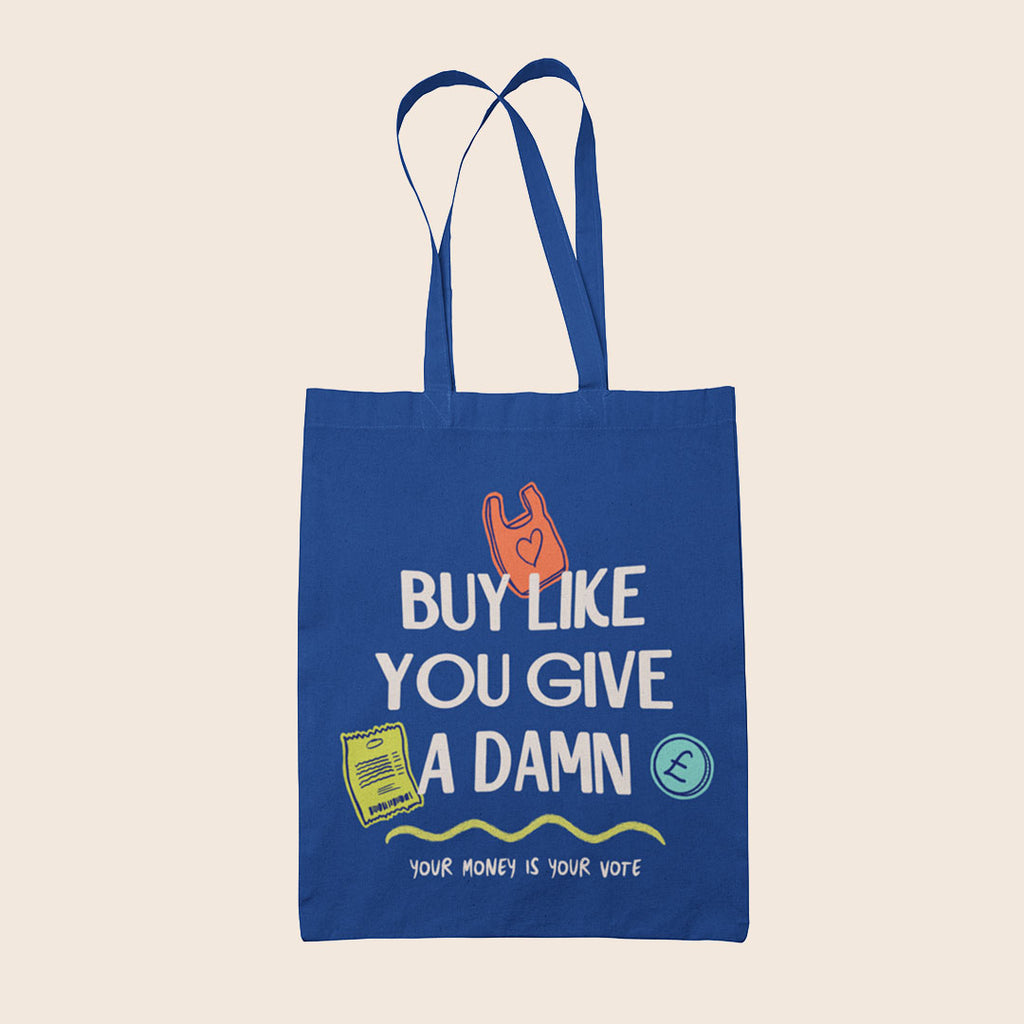 Royal blue cotton tote bag featuring the slogan "Buy Like You Give A Damn" alongside colourful illustrations and the words "Your Money Is Your Vote".