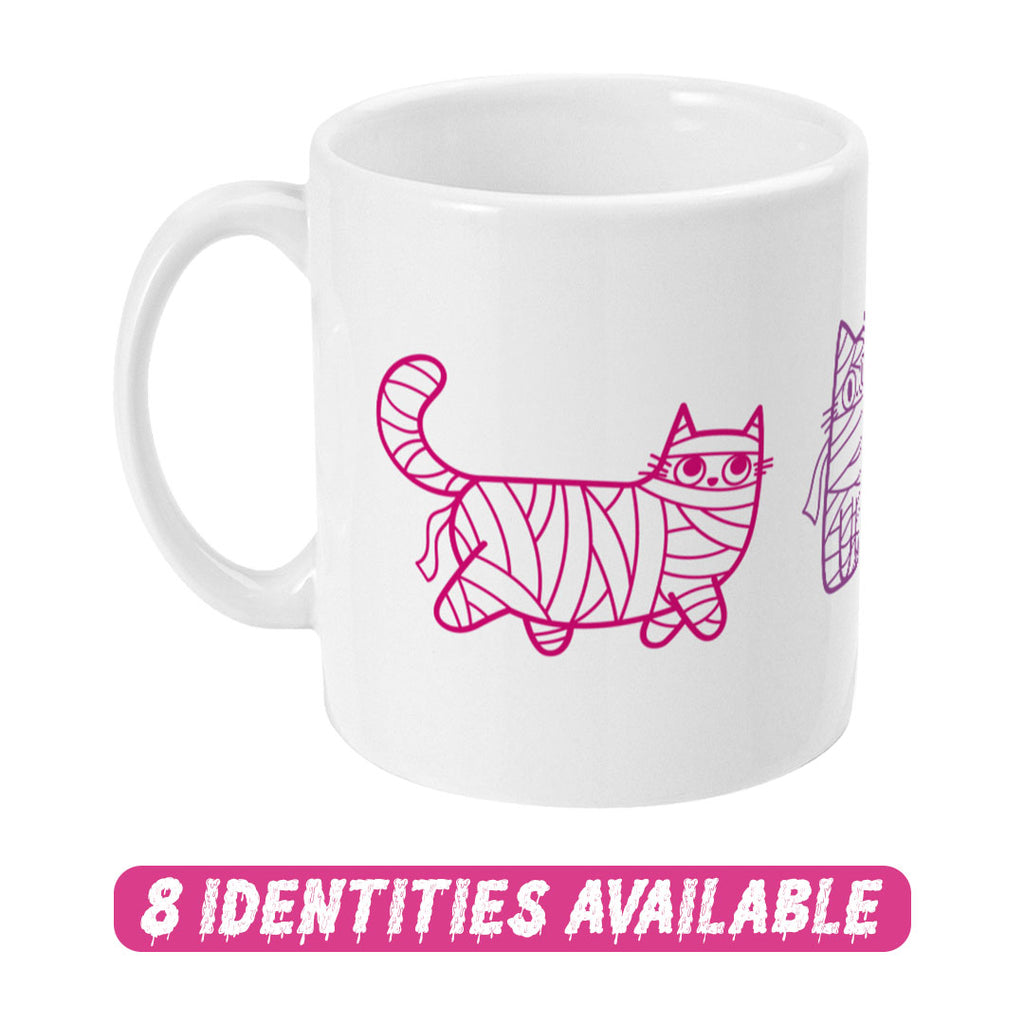 A white ceramic mug featuring a whimsical design of cartoon cats wrapped in mummy bandages, depicted in shades of pink and purple. The artwork highlights three cats in different playful poses, each showcasing their unique personality. Below the mug, a bold pink text reads "8 IDENTITIES AVAILABLE" in a dripping font, indicating the availability of this design in various identity options.