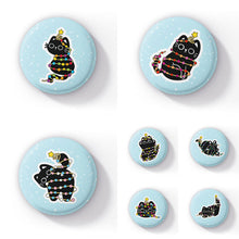 Load image into Gallery viewer, Image featuring a collection of round badges, each displaying a playful black cat tangled in colourful festive string lights, set against a light blue background with white snowflake-like spots. Each badge showcases the cat in different playful poses, with various pride flag colours represented in the lights, including rainbow, transgender, non-binary, and more.