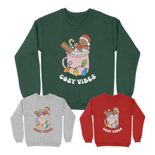 Load image into Gallery viewer, Three sweatshirts with a Cosy Vibes motif in the colours of the rainbow pride flag. One is Bottle Green, one Fire Red, and one Heather Grey.