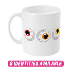 A white ceramic mug featuring three cartoon eyeballs with different coloured irises: one red, one orange, and one yellow. The design showcases playful and spooky elements. Below the mug, the text "8 IDENTITIES AVAILABLE" is displayed in bold, dripping pink letters, indicating that this design is part of a diverse collection with various options.