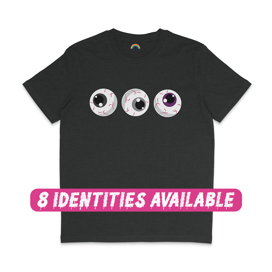 A dark heather grey t-shirt featuring a spooky design of three cartoon eyeballs with detailed red veins. The eyeballs are aligned horizontally across the chest, with the irises coloured in black, grey, white, and purple, representing the Asexual pride flag. Below the design, a pink banner with white, dripping text reads, "8 IDENTITIES AVAILABLE," indicating the shirt is available in multiple pride flag colour variations.