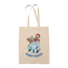 Load image into Gallery viewer, Natural tote bag featuring retro text reading &#39;cosy vibes&#39;. The image shows a mug of hot chocolate with marshmallows and a gingerbread man wearing a Santa hat. A candy cane in the mug and lights around the mug are the colours of the gay pride flag.