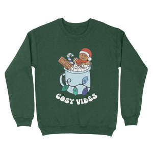 Bottle Green sweatshirt featuring retro text reading 'cosy vibes'. The image shows a mug of hot chocolate with marshmallows and a gingerbread man wearing a Santa hat. A candy cane in the mug and lights around the mug are the colours of the gay pride flag.