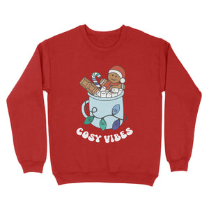 Fire Red sweatshirt featuring retro text reading 'cosy vibes'. The image shows a mug of hot chocolate with marshmallows and a gingerbread man wearing a Santa hat. A candy cane in the mug and lights around the mug are the colours of the gay pride flag.