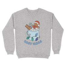 Load image into Gallery viewer, Heather Grey sweatshirt featuring retro text reading &#39;cosy vibes&#39;. The image shows a mug of hot chocolate with marshmallows and a gingerbread man wearing a Santa hat. A candy cane in the mug and lights around the mug are the colours of the gay pride flag.