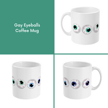 Load image into Gallery viewer, A composite image of a white coffee mug with a cartoon eyeball design in gay pride flag colours.