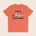 Orange Fiesta T-shirt with four geese dressed in Halloween costumes and the words Be Afraid We Have Pronouns.