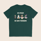 Glazed green T-shirt with four geese dressed in Halloween costumes and the words Be Afraid We Have Pronouns.