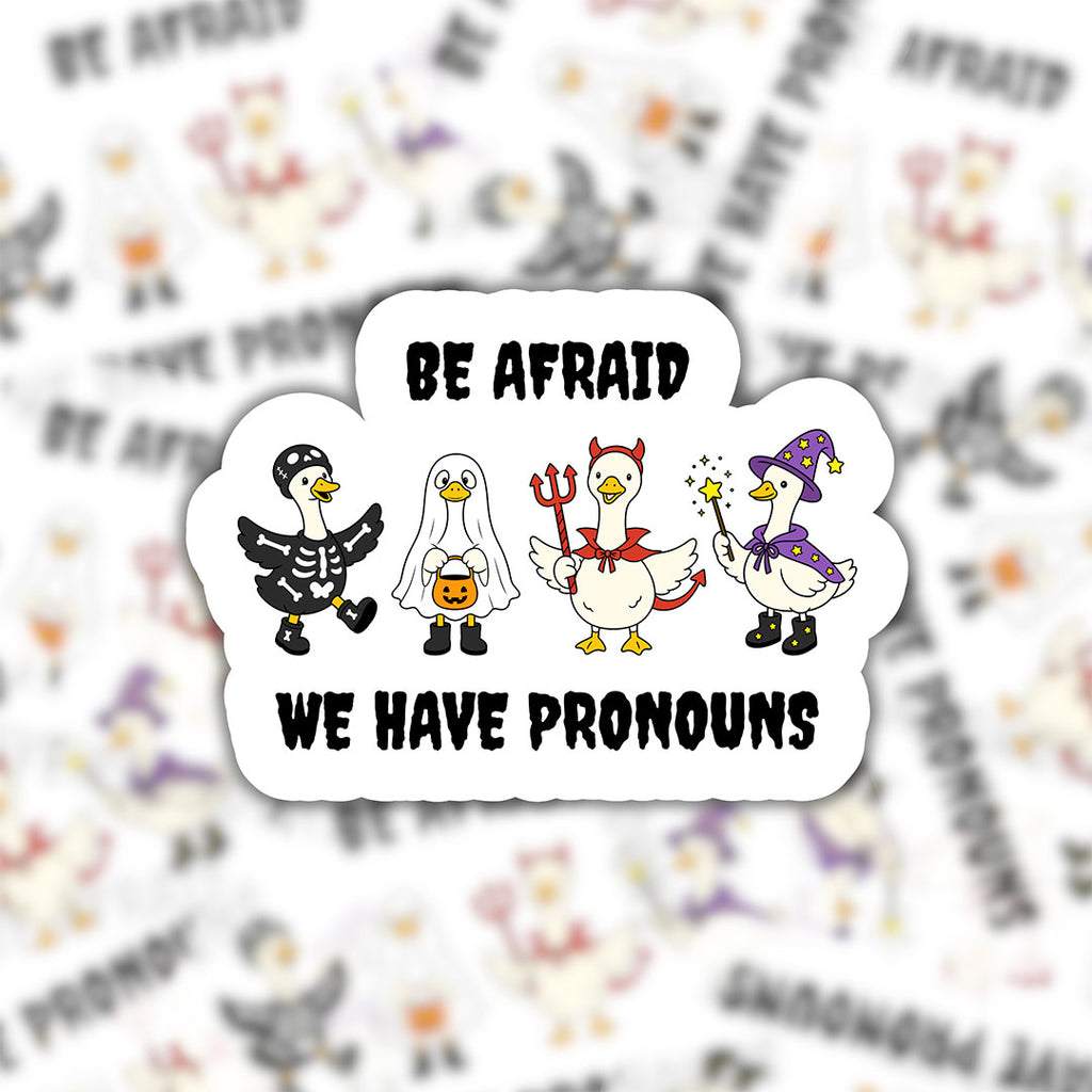 Be Afraid We Have Pronouns goose sticker in the foreground with a blurred repeating pattern of the Halloween goose design behind it.