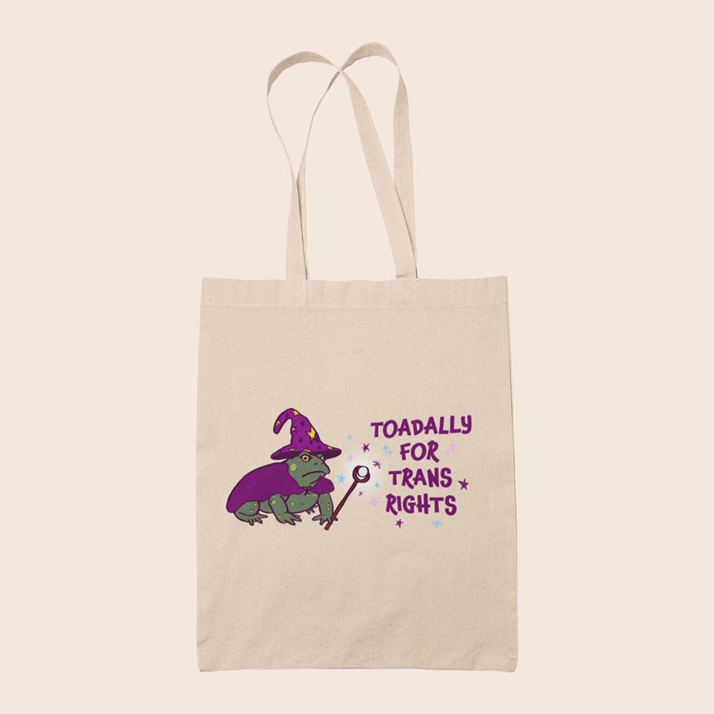 Natural cotton tote bag featuring a wizard toad in purple with the words Toadally For Trans Rights
