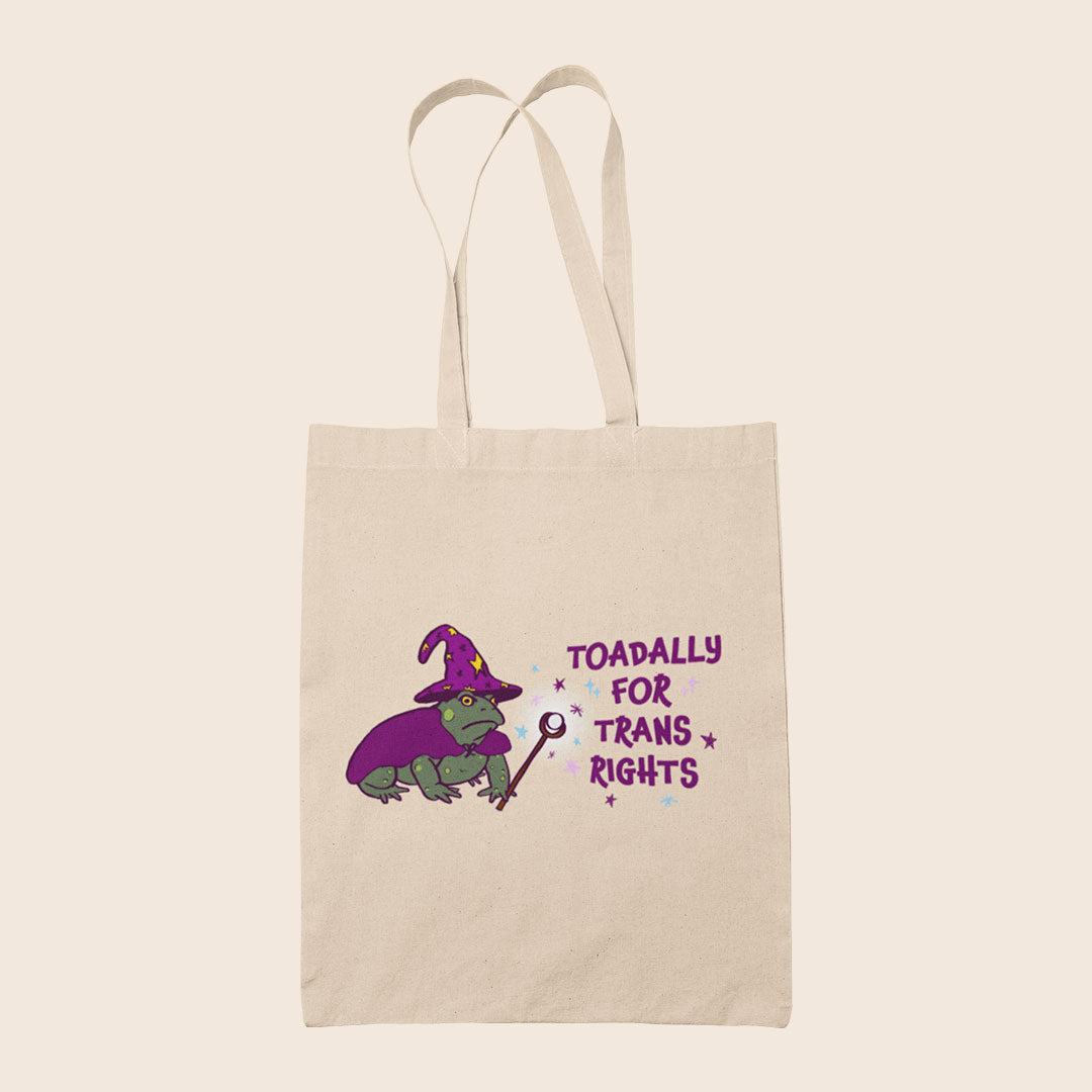 Natural cotton tote bag featuring a wizard toad in purple with the words Toadally For Trans Rights