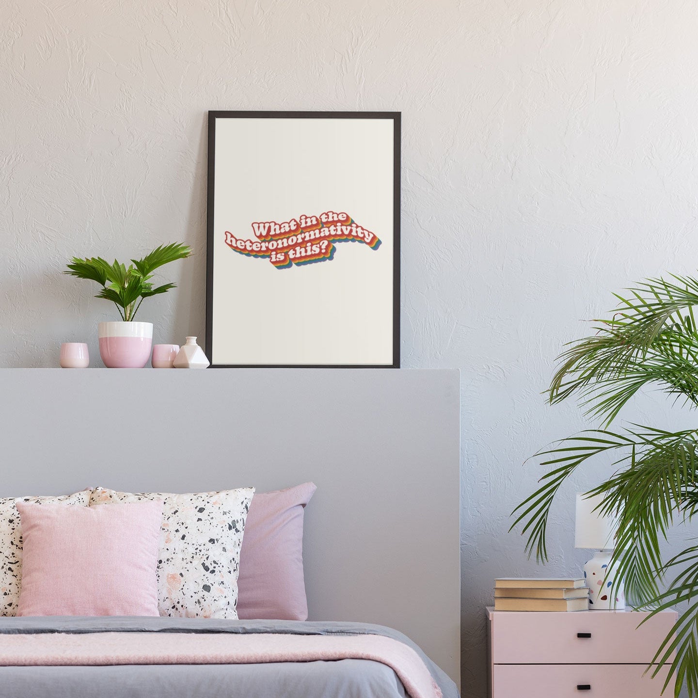 A cosy bedroom with neutral and pastel decor, featuring a What in the heteronormativity is this? print framed and displayed above the bed.