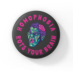 A round badge with a black background featuring a cartoon zombie head with green skin, purple hair, and exposed brain. The text "HOMOPHOBIA ROTS YOUR BRAIN" is written in bold, dripping pink letters around the zombie head.