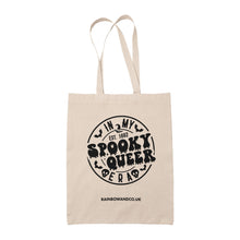 Load image into Gallery viewer, A natural cotton tote bag featuring the same &quot;In My Spooky Queer Era&quot; design as the black version, with a circular white design and spooky-themed elements like bats and skulls. The bag includes the text &quot;RAINBOWANDCO.UK&quot; at the bottom.