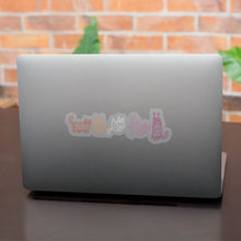 Load image into Gallery viewer, A silver laptop featuring a row of mummy-wrapped cat stickers in the colours of the lesbian flag. The cats are coloured in shades of pink, orange, and white.