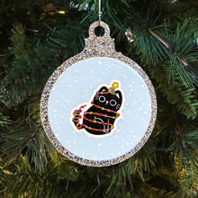 Load image into Gallery viewer, A sparkling Christmas bauble with a black cat tangled in fairy lights in the colours of the lesbian pride flag. The cat sits happily with a star on its head, against a snowy background, hanging on a Christmas tree.