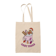 Load image into Gallery viewer, Natural tote bag featuring retro text reading &#39;cosy vibes&#39;. The image shows a mug of hot chocolate with marshmallows and a gingerbread man wearing a Santa hat. A candy cane in the mug and lights around the mug are the colours of the lesbian pride flag.
