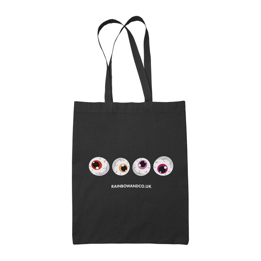 A black tote bag with four cartoonish eyeballs aligned in a row. The colours of the eyeballs include red, orange, and pink. The bottom of the design features the text "RAINBOWANDCO.UK".