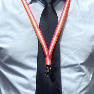 Person wearing a lanyard in the colours of the lesbian flag over a shirt and tie.