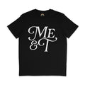 Flat lay of a black t-shirt with bold white text reading “Me & T” in a decorative serif font. The inside neckline features a rainbow logo with the website rainbowandco.uk.
