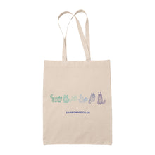 Load image into Gallery viewer, A natural canvas tote bag displaying a line drawing of six mummy cats in shades of green, teal, and blue, representing the colours of the Gay pride flag. Each cat is wrapped like a mummy, with distinctive poses and expressions.