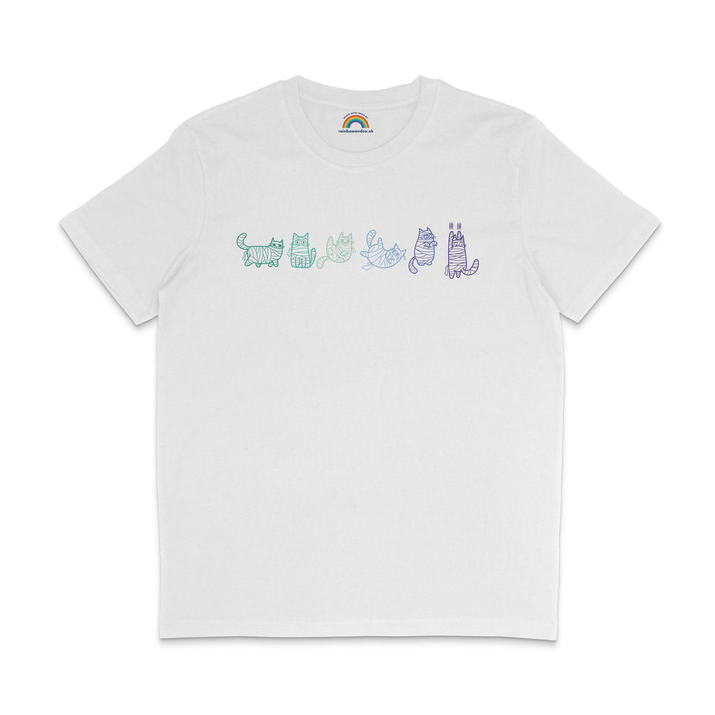 A white T-shirt displaying six mummy cat illustrations in the colours of the gay pride flag. Each cat is wrapped in bandages and has a different pose and expression, with the designs drawn in shades of green, teal, blue, and purple.