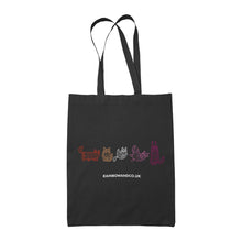 Load image into Gallery viewer, A black tote bag showcasing five mummy cats in various colours representing the lesbian pride flag: orange, white, pink, and magenta. Each cat has a unique pose and expression. The text &quot;rainbowandco.uk&quot; is placed beneath the design.