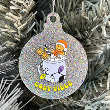 Load image into Gallery viewer, Close up of a white Christmas tree displaying a silver glitter bauble featuring retro text reading &#39;cosy vibes&#39;. The image shows a mug of hot chocolate with marshmallows and a gingerbread man wearing a Santa hat. A candy cane in the mug and lights around the mug are the colours of the non binary pride flag.