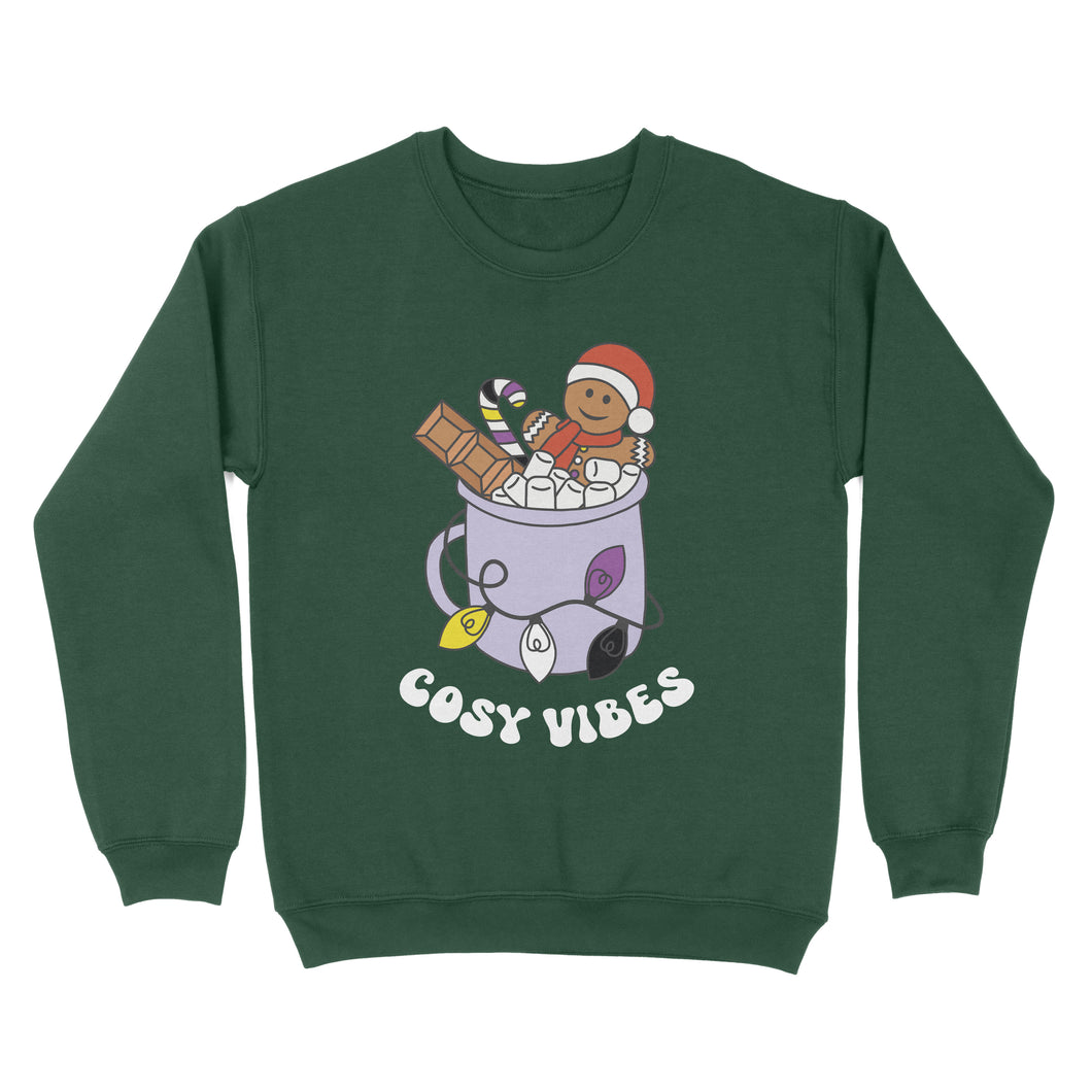 Bottle Green sweatshirt featuring retro text reading 'cosy vibes'. The image shows a mug of hot chocolate with marshmallows and a gingerbread man wearing a Santa hat. A candy cane in the mug and lights around the mug are the colours of the non binary pride flag.