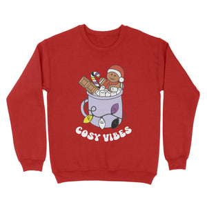 Fire Red sweatshirt featuring retro text reading 'cosy vibes'. The image shows a mug of hot chocolate with marshmallows and a gingerbread man wearing a Santa hat. A candy cane in the mug and lights around the mug are the colours of the non binary pride flag.