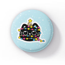 Load image into Gallery viewer, A black cat wrapped in string lights in the colours of the pansexual flag (pink, yellow, and blue), standing upright on a light blue background with snowflakes.