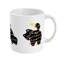 Load image into Gallery viewer, A white ceramic mug displaying the same black cat facing sideways, as the lights and a golden star twirl around its body, with its tail adorned like a Christmas tree topper.