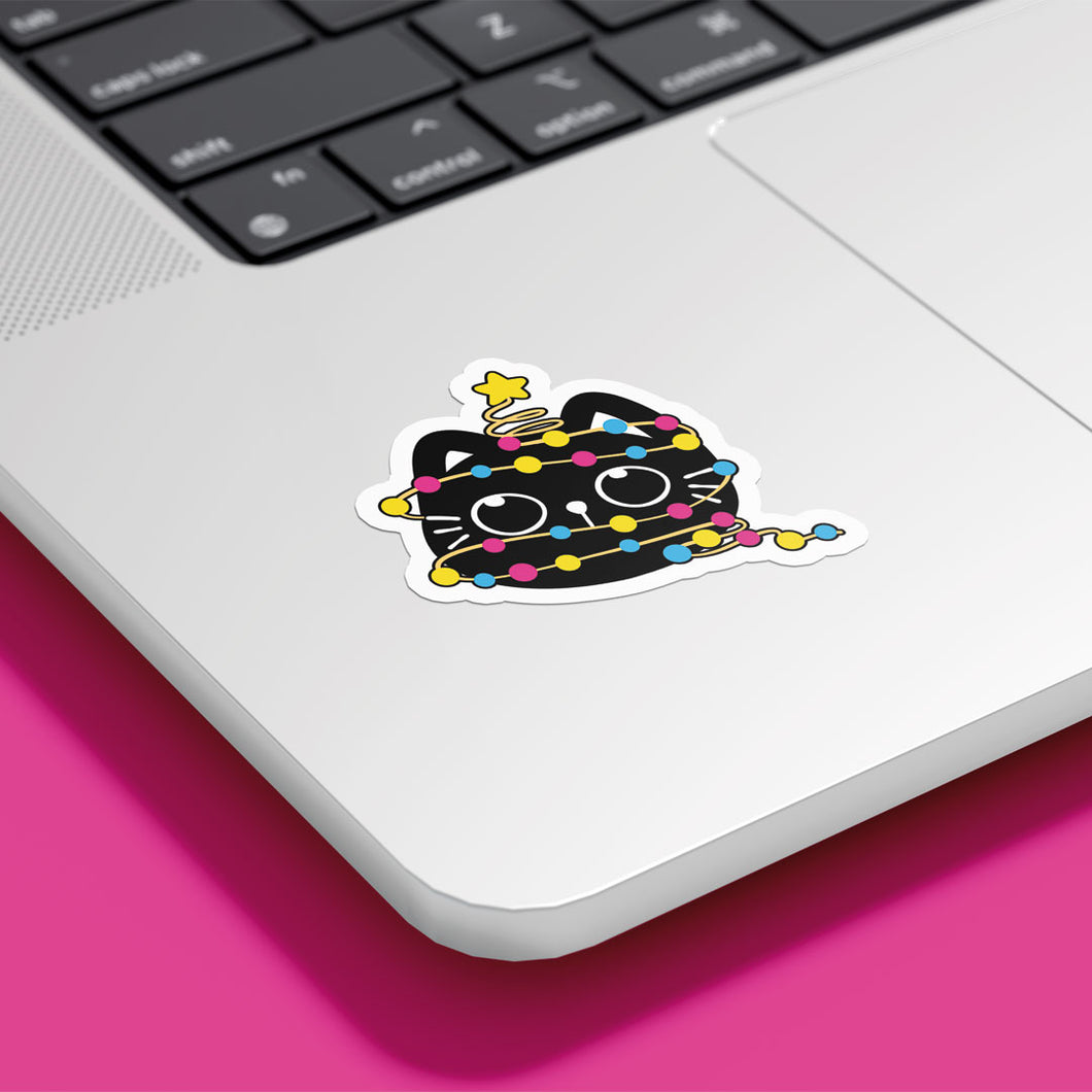 A playful black cat wrapped in Pansexual pride-coloured string lights (pink, yellow, blue) is sitting with a yellow star on its head. The sticker is placed on a laptop surface.