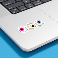 Load image into Gallery viewer, Three circular stickers with eyeball designs are placed on the bottom corner of a silver laptop. The irises are pink, yellow, and blue, representing the pansexual pride flag.